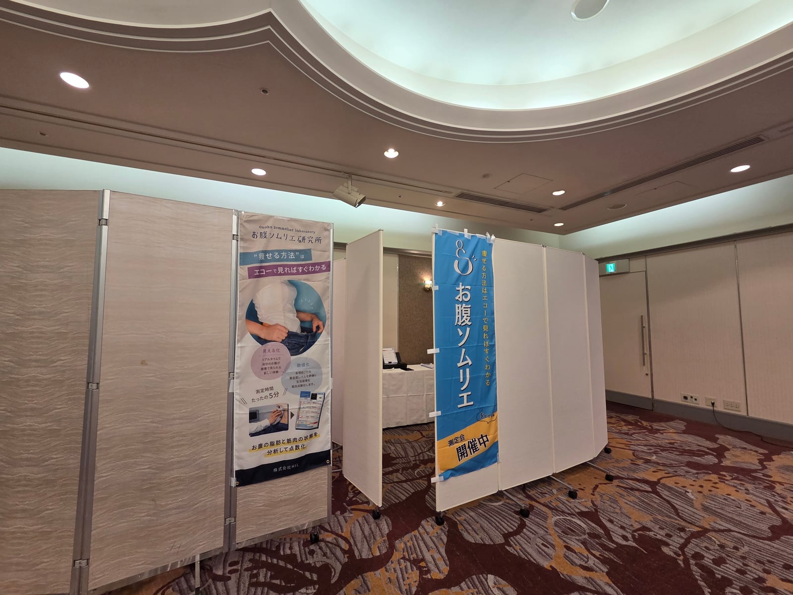 会場に設営された健康測定会のブース。パーテーションとのぼりで「測定会 開催中」と案内された福利厚生イベントの様子